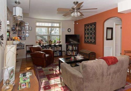 Decorated living room with couch, chair, TV at 塞奇威克花园 apartments in 费城, PA.