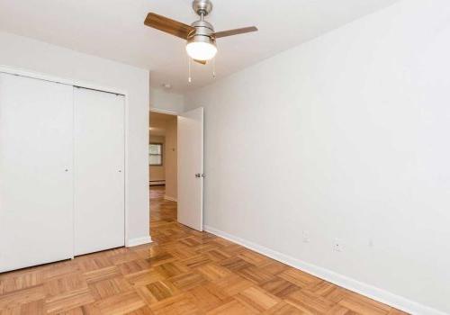 Bedroom with ample closet space, hardwood floors, and ceiling fan at Sedgwick Terrace apartments.