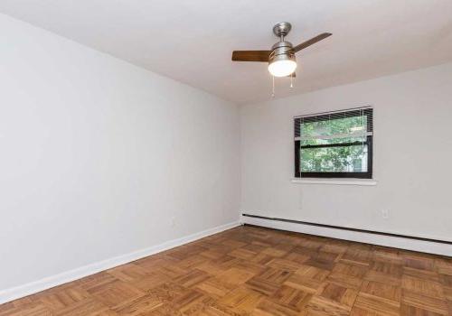 Bedroom with hardwood floors, window lighting, and ceiling fan at 塞奇威克露台 apartments.